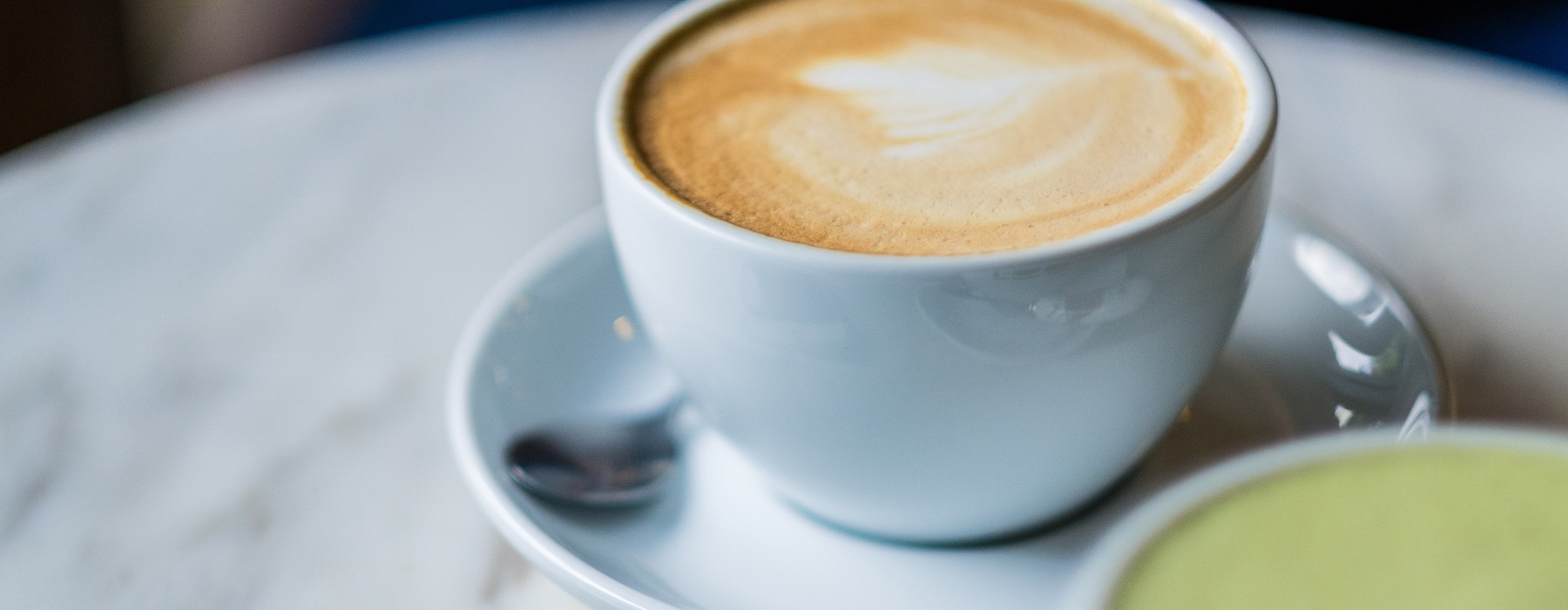 a cup of coffee on a table with tea